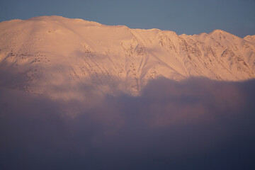 Naklejka premium sunset in the snowy mountains of the southern alps france with fog