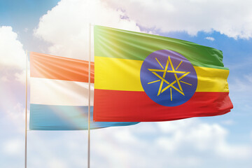 Sunny blue sky and flags of ethiopia and luxembourg