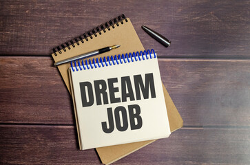 dream job words on paper notebook on wooden background
