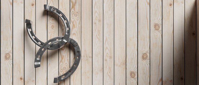 Silver horseshoe on wooden plank empty background. Copy space, banner. 3d illustration