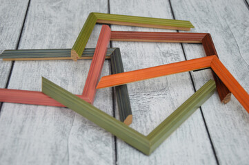 Decorative modern colored picture frames. Patterns of frames for a baguette, lying on a wooden background. Workshop
