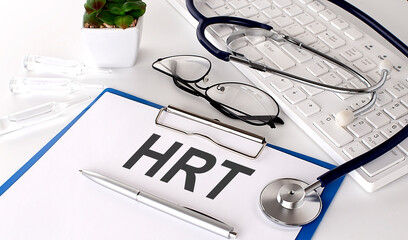HRT text on white paper on white background. stethoscope ,glasses and keyboard