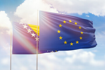 Sunny blue sky and flags of european union and bosnia