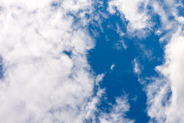 A clear patch of sky among white clouds.