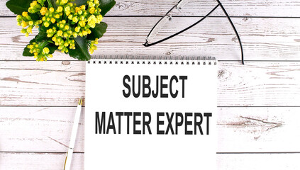 SUBJECT MATTER EXPERT text concept write on notebook on wooden background