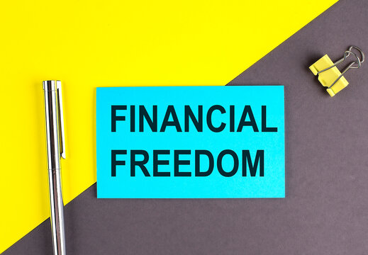 FINANCIAL FREEDOM text written on sticky with pen on grey, yellow background, business concept