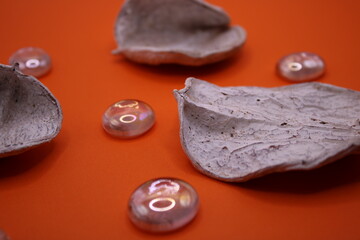 White potpourri on an orange background with glass marbles