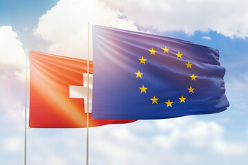 Sunny blue sky and flags of european union and switzerland