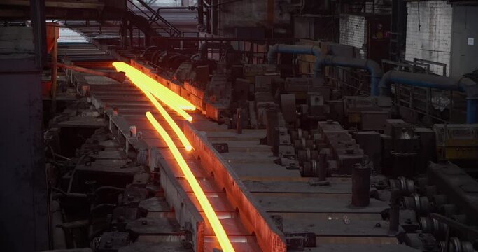 Hot steel rail on a conveyor in a metallurgical plant. Rolling shop. Business concept, modern steel production technology
