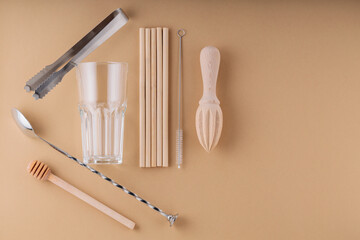 Cocktail spoon, ice tongs and glass for summer drink. Bamboo straws, cleaning brush and wooden...