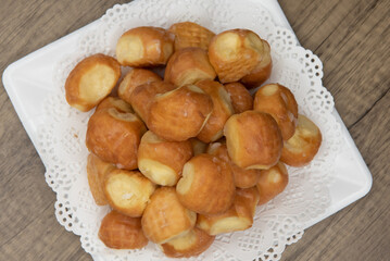Overhead view of tempting fresh from the oven glazed donut holes from the bakery stacked on a plate