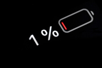 Low level of smartphone charged battery level indicator - one, 1 percent: close up macro view of...
