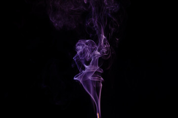 incense stick with smoke against black background