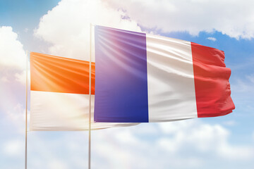 Sunny blue sky and flags of france and indonesia