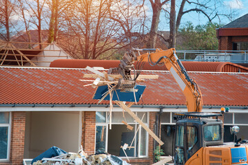 Demolition of building. Excavator breaks old house. Making space for the construction of a new...