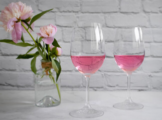 Rose wine, peony flower on a light background