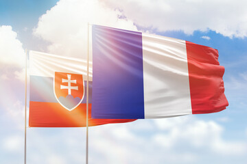 Sunny blue sky and flags of france and slovakia