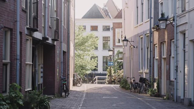 Amsterdam's narrow street with old brick houses on a sunny day. Quiet morning in a little town in Netherlands. Old European houses with red bricks. High quality 4k footage