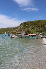 Trpejca Beachfront, beach with boats and crystal clear water in North Macedonia
