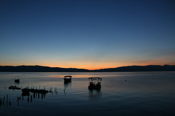 Spectacular sunset over lake next to boats in Ohrid, North Macedonia