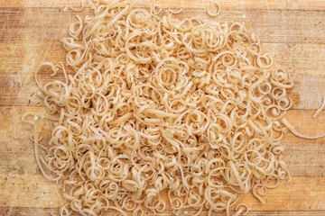 Soap shavings on a wooden board. Small spirals of grated laundry soap