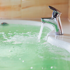 single handle faucet pouring hot water in a bath tub