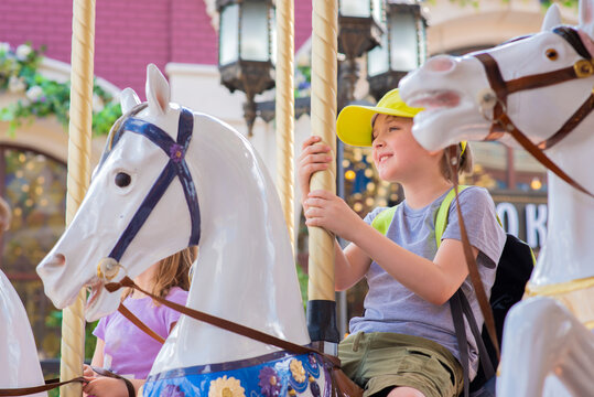 little boy riding a carousel merry-go-round  in summer