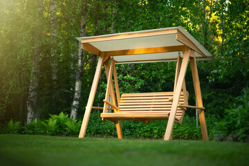 Wooden swing in the green garden. Recreation in the park. Garden design. Relax in the fresh air....