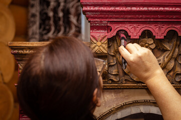 Woman creatively restoring antique wooden cupboard with hand carved ornaments. Re-usage of old...