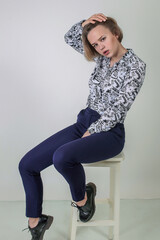 Portrait of a beautiful fashion woman blond in a art business suit in the studio