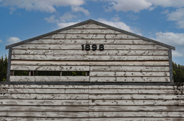 Skagway, Alaska, USA - July 20, 2011: Closeup of old gray wooden barn top level with 1898 date...