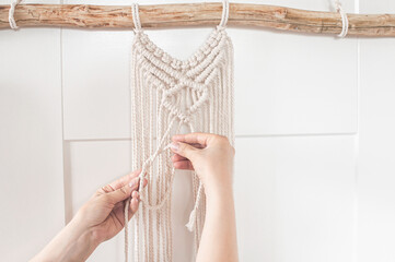 Girl weaving a macrame pattern for a large wall panel