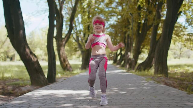 Athletic fitness sport runner child girl finishing racing competition. Victory and success. Workout cardio training in park. Toddler kid jogger champion winning marathon. Active children motivation