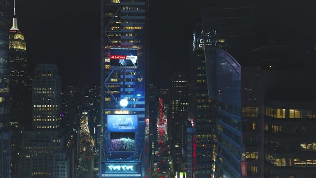 Aerial descending footage of high rise downtown buildings at night. Visual effects adding large screen on facade. Manhattan, New York City, USA