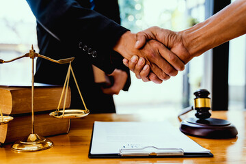 Male lawyer with client shaking hands in office