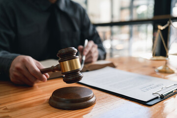 Lawyer or judge holding Hammer prepares to judge the case with justice, and litigation, scales of justice, law hammer,  Legal consulting services, Concept of litigation, and legal services.