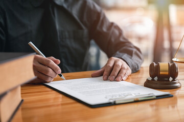Lawyer man holding pen with contract or agreement document to the customer for signing in courtroom legal, Sign a contract business.