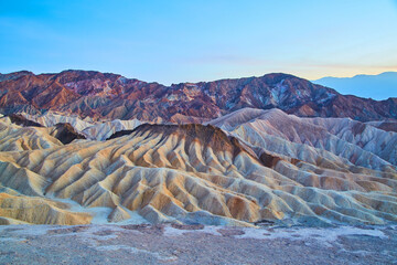 Soft dusk light at Zabriskie Point with colorful waves of sediment