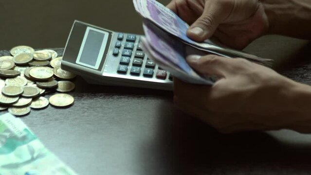 preparando el presupuesto para los gastos del mes esta un joven colombiano contando los billetes de su salario