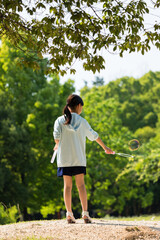 夏の公園でシャボン玉を遊んでいる小学生の女の子の様子