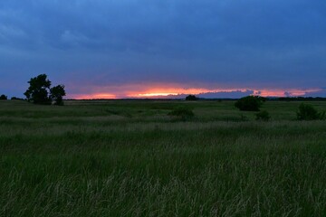 Naklejka na ściany i meble Dramatic Sunset Over a Rural Field