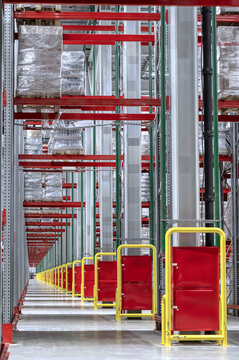 Lifting equipment with cargo near high shelving in storage
