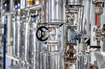 Large tube with small black valve at production plant