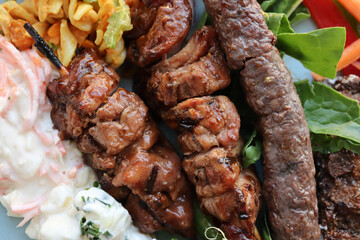 South African braai meat. Chicken kebabs and boerewors sausage with potato salad, coleslaw and curry pasta salad 