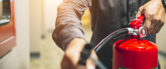 Fire extinguisher has hand engineer checking to prepare fire equipment for protection and prevent...