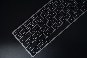 space gray keyboard on a black background. bluetooth keyboard with english and russian layout