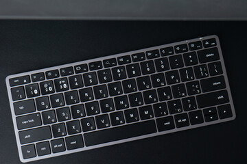 space gray keyboard on a black background. bluetooth keyboard with english and russian layout