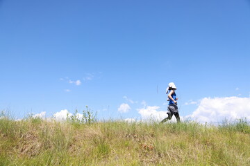 タオルを被ってジョギングする女性の後ろ姿