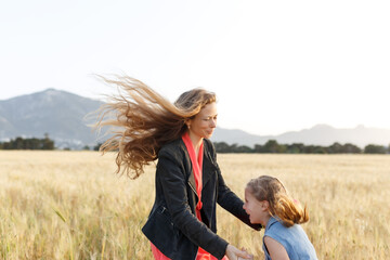 Family fun. Mother and daughter jumping in the field