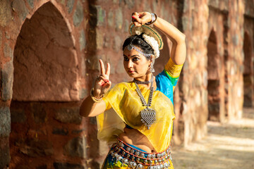 Indian woman Odissi dancer doing classical dance form outdoor at heritage place. Orissi dance. art...